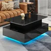 A modern living room scene featuring a black high-gloss coffee table with LED lighting, placed in front of a caramel-colored sofa. Produktbild-Vorschau