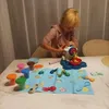 A young child is playing with a play-doh set on a table. Anteprima dell’immagine prodotto