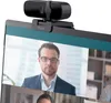 A webcam is attached to the top of a laptop screen, showing a video call with a man in a suit. Náhľad obrázku produktu