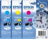 The image shows three Epson ink cartridges (Cyan, Yellow, and Magenta) in their packaging, along with a partial image of an alarm clock. Náhľad obrázku produktu