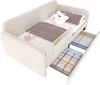 A white children's sofa bed with two pull-out drawers filled with folded blankets and bedding. Decorative pillows and a small flamingo toy are on the bed. Náhled obrázku produktu
