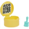 A yellow toy accessory container with a QR code on the lid and a small blue brush next to it. Produktbild-Vorschau