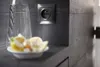 A close-up shot of a wall socket and a glass of water with sliced lemons on a shelf. Anteprima dell’immagine prodotto