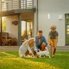 A family playing with their dog in the backyard of a modern house. Produktbild-Vorschau