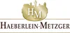 A logo with the letters HM inside a golden oval shape, with a silhouette of buildings above it. Below the oval, the text 'HAEBERLEIN-METZGER' is displayed. Náhled obrázku produktu