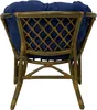 The back view of a rattan chair with a blue cushion. Produktbild-Vorschau