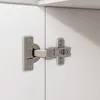 Close-up of a cabinet hinge attaching two white cabinet doors. Náhľad obrázku produktu