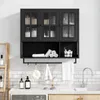 A black wall-mounted cabinet with glass doors, containing toiletries and towels, above a countertop with a sink and faucet. Produktbild-Vorschau