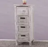 A white wooden chest of drawers with four drawers, placed on a gray carpet in front of a light purple wall. Podgląd zdjęcia produktu