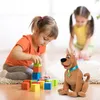 Two young girls are playing with colorful blocks and a stuffed Scooby-Doo toy on the floor. Náhled obrázku produktu