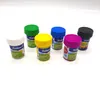 Six small paint pots with colorful lids arranged on a white background. Produktbild-Vorschau