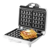 A white waffle maker with two waffles topped with butter. Podgląd zdjęcia produktu