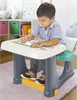 A young boy is drawing at a child's desk in a room with shelves and toys. Náhľad obrázku produktu