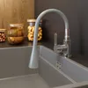 A close-up view of a kitchen sink with a gray faucet and a flexible spout. Podgląd zdjęcia produktu