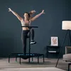 A woman is exercising on a trampoline in a living room. Voir les images du produit