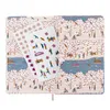 An open notebook with a decorative cover depicting a park scene with people, trees, and a lake. Two sticker sheets are placed on the left page. Produktbild-Vorschau