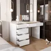 A modern white desk with drawers, a laptop, and decorative items in a bedroom setting. Produktbild-Vorschau