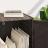 A close-up view of a brown poly rattan storage box with cushions inside and books on top. Podgląd zdjęcia produktu