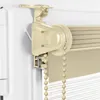 Close-up view of a cream-colored roller blind mechanism attached to a window frame. Produktbild-Vorschau