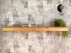 A wooden shelf mounted on a textured gray wall, with two books and a potted plant on it. Produktbild-Vorschau