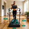 A woman is running on a treadmill in a home or office setting. Produktbild-Vorschau