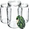Four empty glass jars are arranged in a studio setting with a close-up of a lid featuring pickles in the foreground. Podgląd zdjęcia produktu