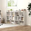 A white geometric bookshelf filled with various decorative items and books, placed in a room with a window and a plant. Produktbild-Vorschau