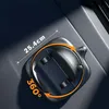 A close-up shot of a black car phone mount with orange accents, placed on a textured dark gray surface, likely a car interior. Arrows indicate 360-degree rotation, and a dashed line with text indicates a measurement. Náhled obrázku produktu
