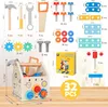 A wooden toy toolbox with various tools and building components, along with a booklet, displayed on a wooden surface. Produktbild-Vorschau