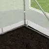 Close-up view of the corner of a greenhouse with soil in the foreground and the transparent PE cover and metal frame visible. Produktbild-Vorschau
