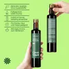 Two bottles of black cumin seed oil are shown, one held by a hand, with text overlays describing product features. Produktbild-Vorschau