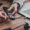 A person is using a card reader connected to a laptop, inserting an SD card. Produktbild-Vorschau