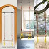 A collage of three images showing a wooden trapeze swing in different settings: indoors attached to a doorframe, indoors attached to a ceiling beam, and outdoors attached to a tree branch. Produktbild-Vorschau