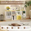 A white and yellow cube storage shelf unit filled with books, decorative items, and storage boxes, placed on a light gray carpet. The top of the unit has a yellow surface. Produktbild-Vorschau