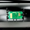 A close-up of a circuit board with text on it, mounted on a black plastic component. Produktbild-Vorschau