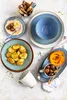 A top-down view of a table setting with various dishes and tableware. Produktbild-Vorschau