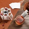 A collection of tea bags filled with various dried herbs and flowers, with one tea bag being steeped in a glass teapot. Produktbild-Vorschau