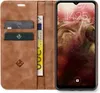 A brown leather flip case for a smartphone, with cards and a banknote inserted. Produktbild-Vorschau