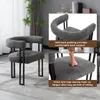 A dark gray armchair with black metal legs is shown in a room with a plant and curtains. Insets highlight the soft back padding and high-density foam seat. Produktbild-Vorschau