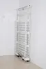 A tall, multi-tiered drying rack with wheels, positioned in a corner against a tiled wall. Produktbild-Vorschau