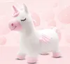 A plush white unicorn toy with pink accents, set against a soft pink background with blurred pink bubbles. Náhľad obrázku produktu