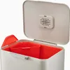 A close-up view of an open trash can with an orange inner bin. Podgląd zdjęcia produktu