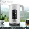 A white electric kettle with a digital display is placed on a marble countertop in front of a scenic view of mountains and trees. Náhled obrázku produktu