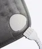 A close-up view of a gray electric heating pad with a white control unit and power cord. Náhled obrázku produktu
