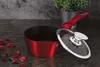 A red pot with a glass lid sits on a dark countertop, with decorative dried flowers and a potted plant in the background. Anteprima dell’immagine prodotto