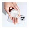 A hand holding a white retractable charging cable over a smartphone. Anteprima dell’immagine prodotto
