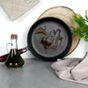 A cast iron frying pan with oil in it, a bottle of olive oil, and a piece of wood on a gray surface. Voir les images du produit