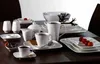 A table setting with white dinnerware and coffee cups. Voir les images du produit