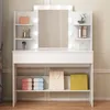 A white makeup vanity with a lighted mirror and shelves, displaying various cosmetic items and shopping bags. Náhled obrázku produktu