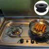 A close-up view of a camper stove with sausages cooking in a pan, and a product detail image of a rubber foot in the upper right corner. Produktbild-Vorschau